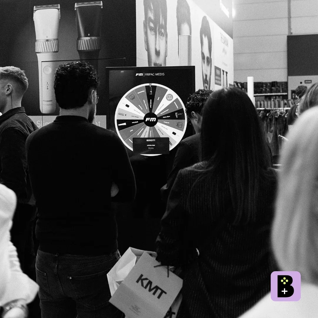 FRIPAC-MEDIS trade show booth at Top Hair 2026 with a digital Spin the Wheel game on the screen